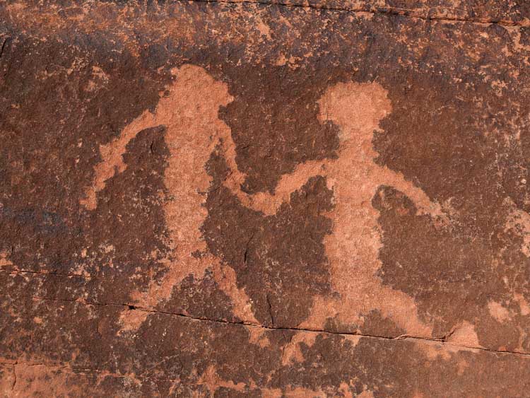 Ancient American Indian petroglyph on a red sandstone wall.